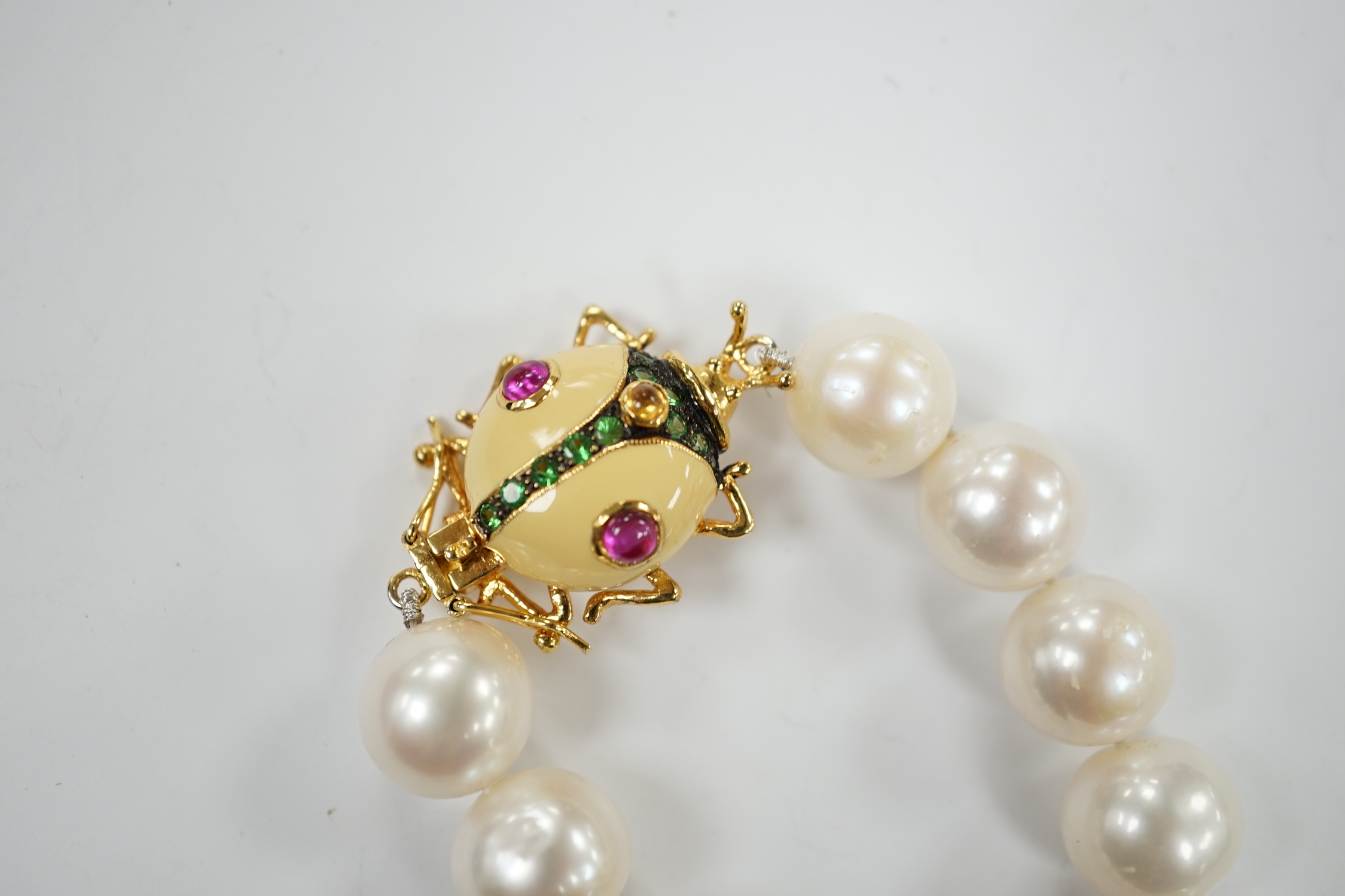 A Butler & Wilson single strand cultured pearl necklace, with enamelled and gem set bug clasp, 43cm.